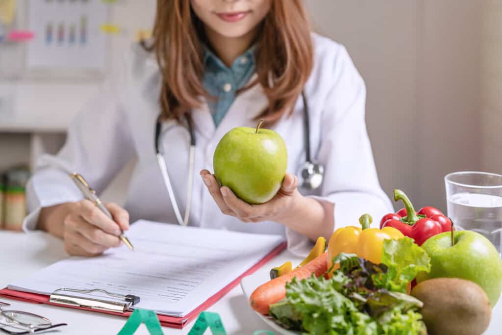 Nutritionist,Giving,Consultation,To,Patient,With,Healthy,Fruit,And,Vegetable,