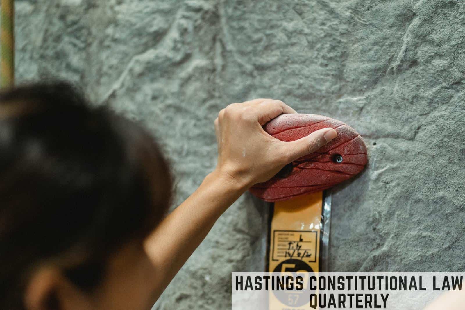 Woman touching climbing hold on rocky wall
