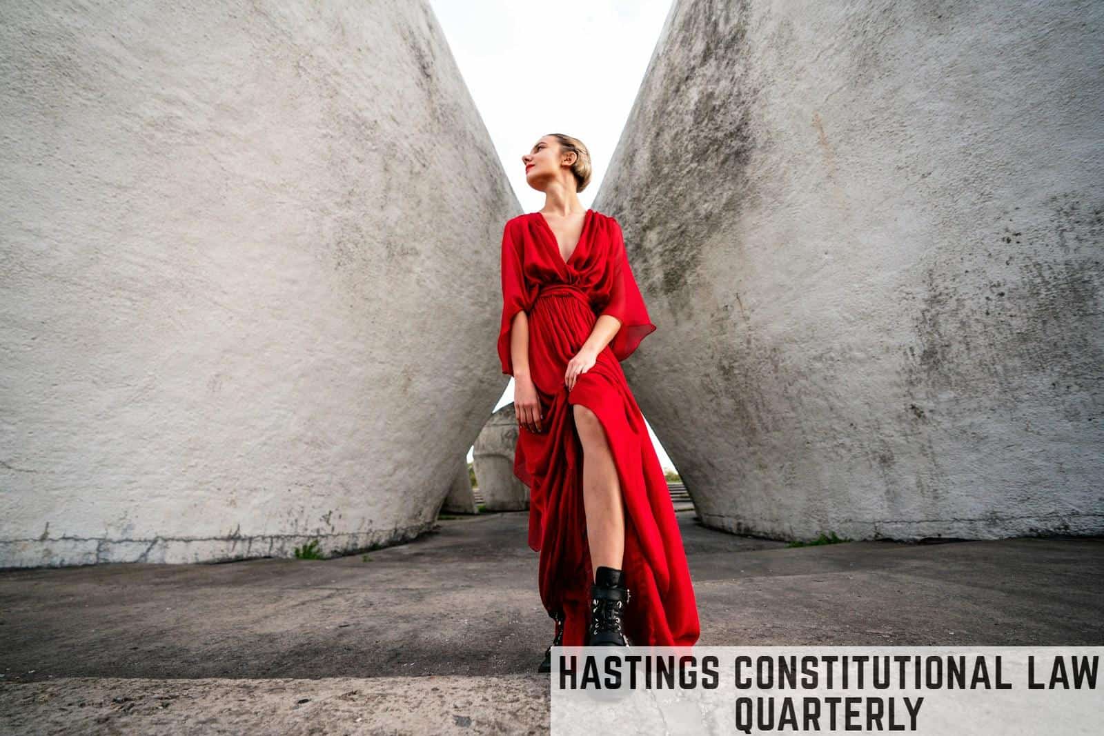 woman in red long sleeve dress and black boots standing beside gray concrete wall during daytime