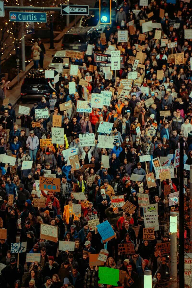 Multitud con pancartas en una manifestación nocturna en defensa de derechos fundamentales